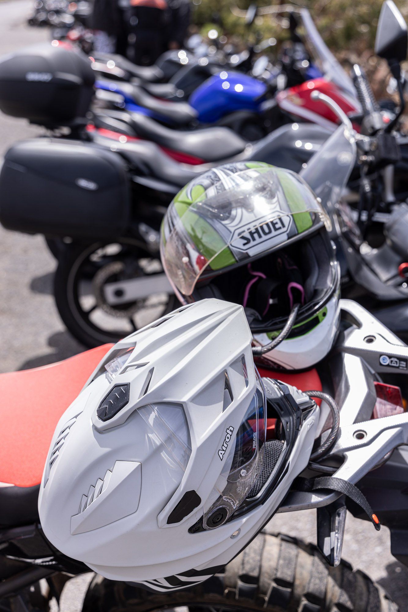 A helmet is sitting on the back of a motorcycle.