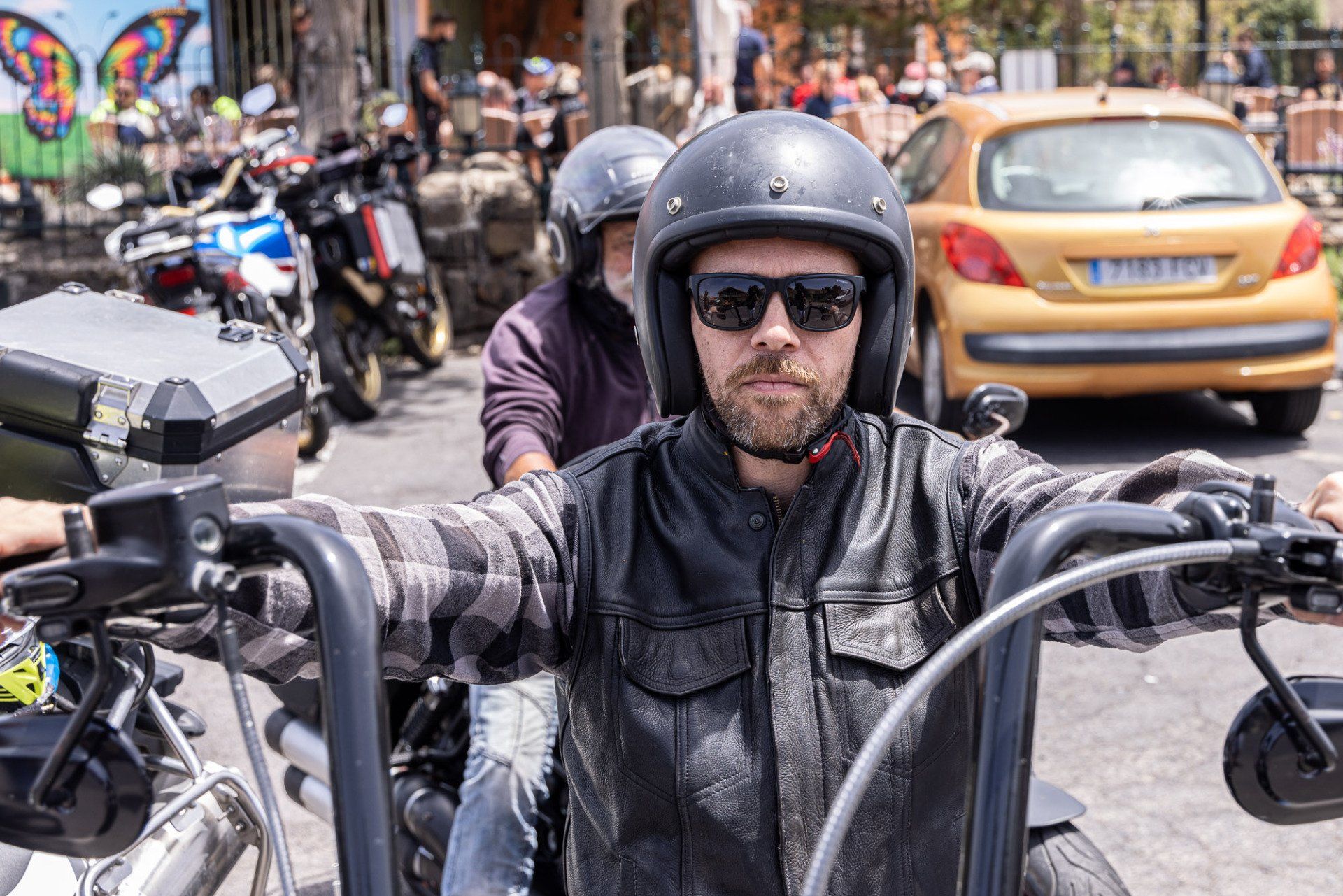 A man wearing a helmet and sunglasses is riding a motorcycle.