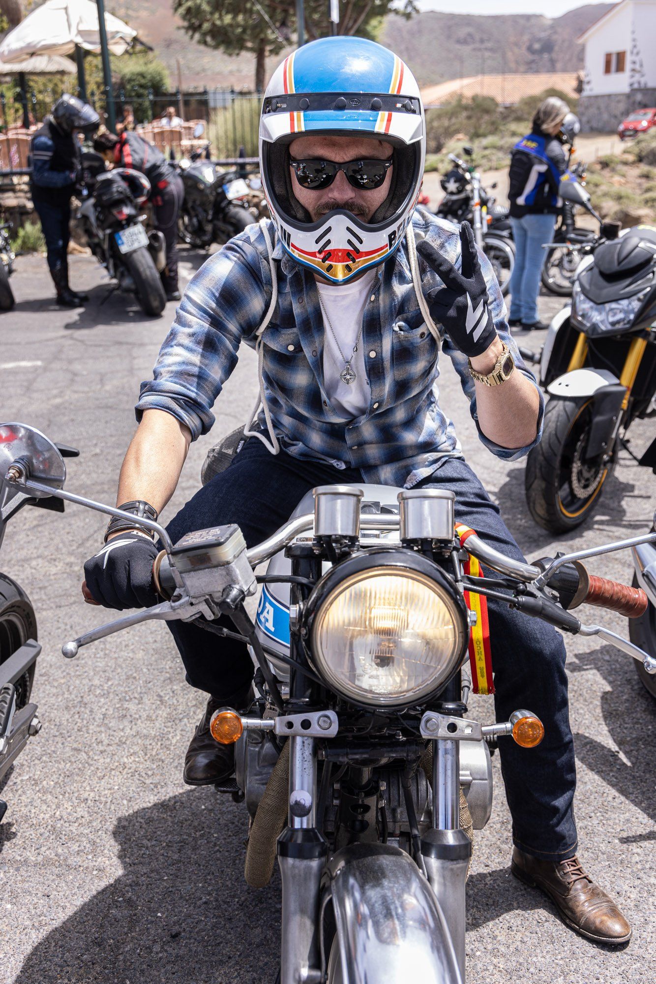 A man wearing a helmet and sunglasses is sitting on a motorcycle.
