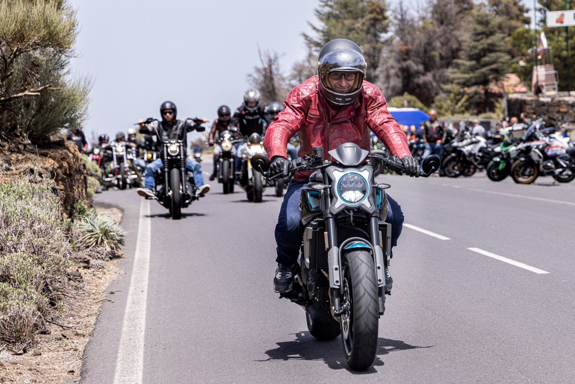 A group of people are riding motorcycles down a road.