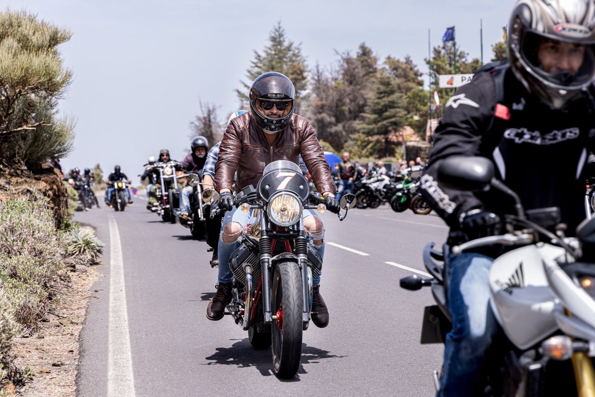 A group of people are riding motorcycles down a road.