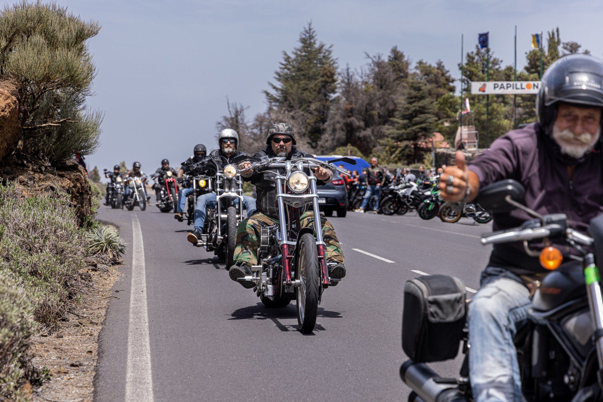 A group of people are riding motorcycles down a road.