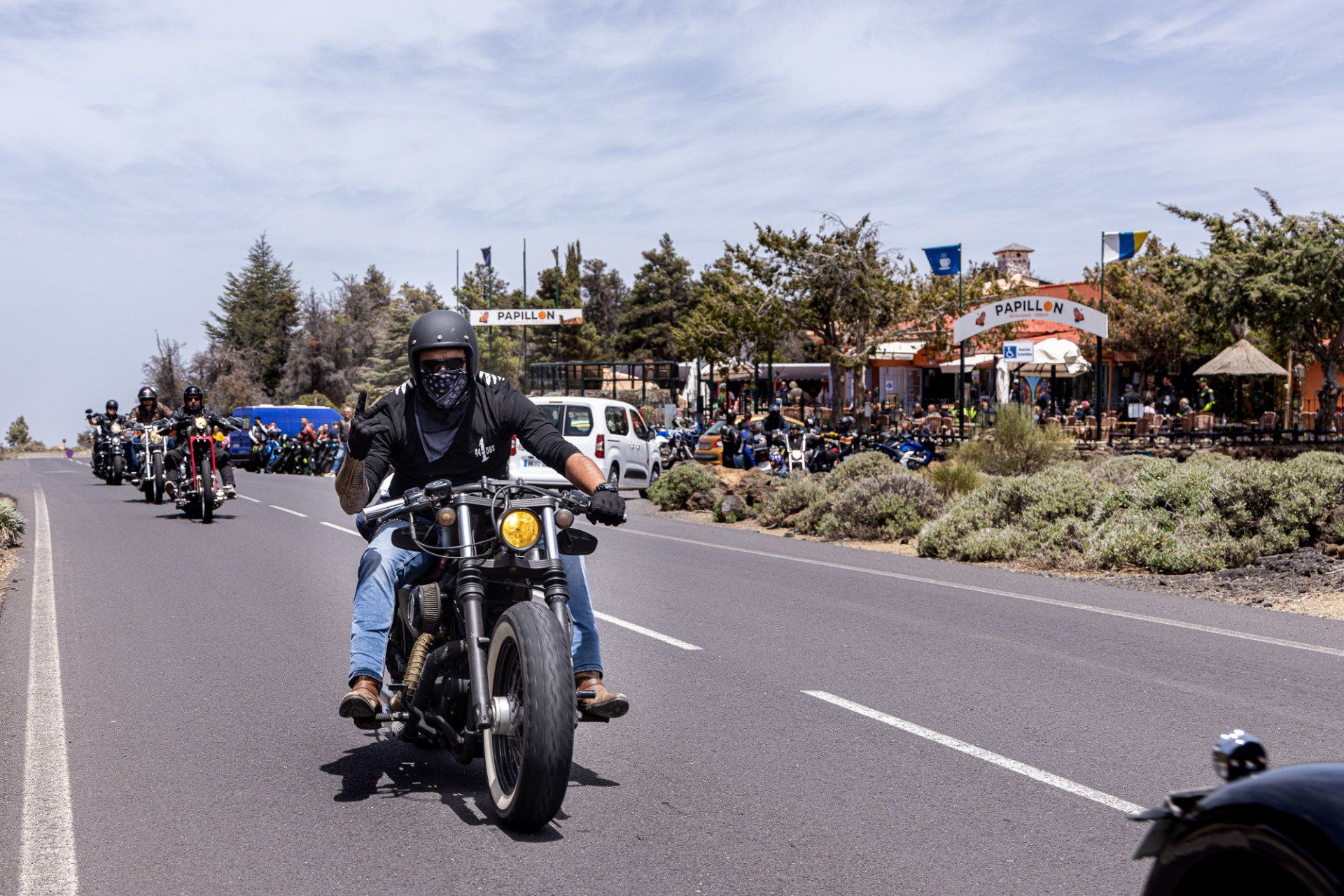 A group of people are riding motorcycles down a road