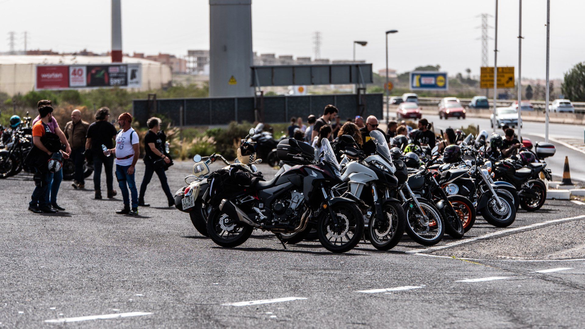 A row of motorcycles are parked on the side of the road.