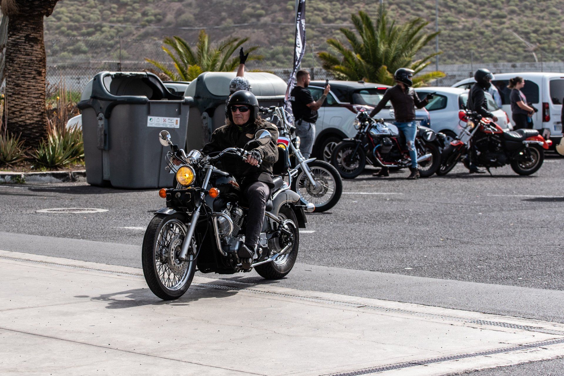 A man is riding a motorcycle down a street.