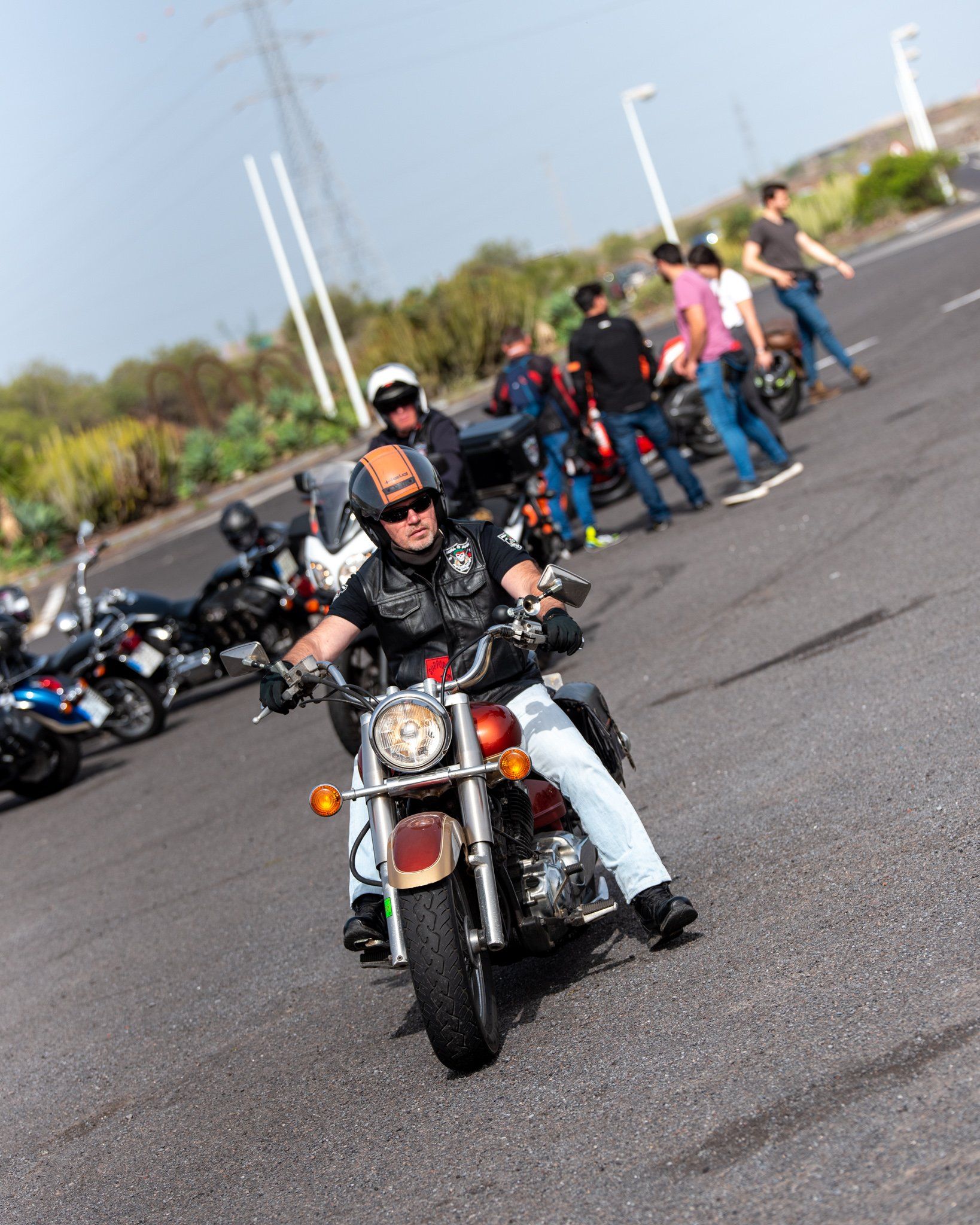 A man is riding a motorcycle in a parking lot