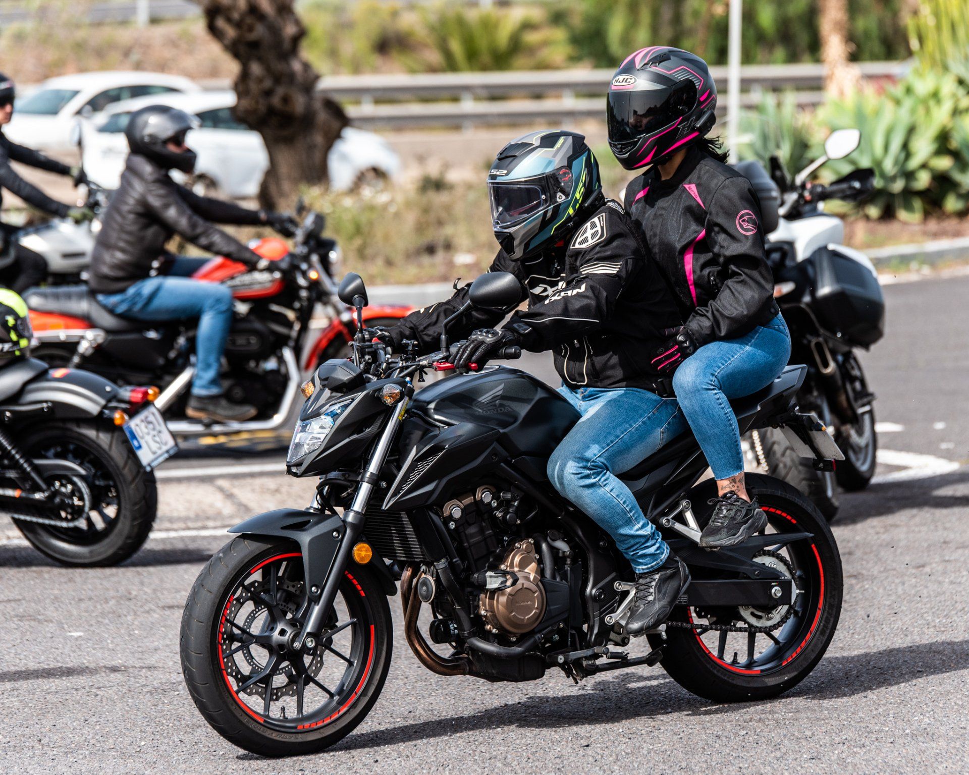 A group of people are riding motorcycles down a street.