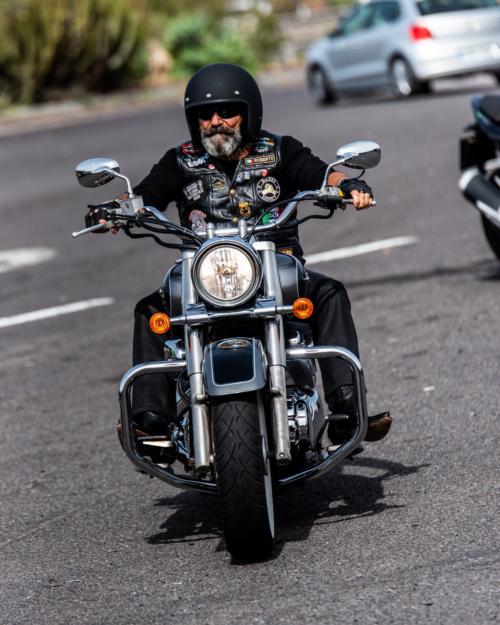 A man is riding a motorcycle down a street