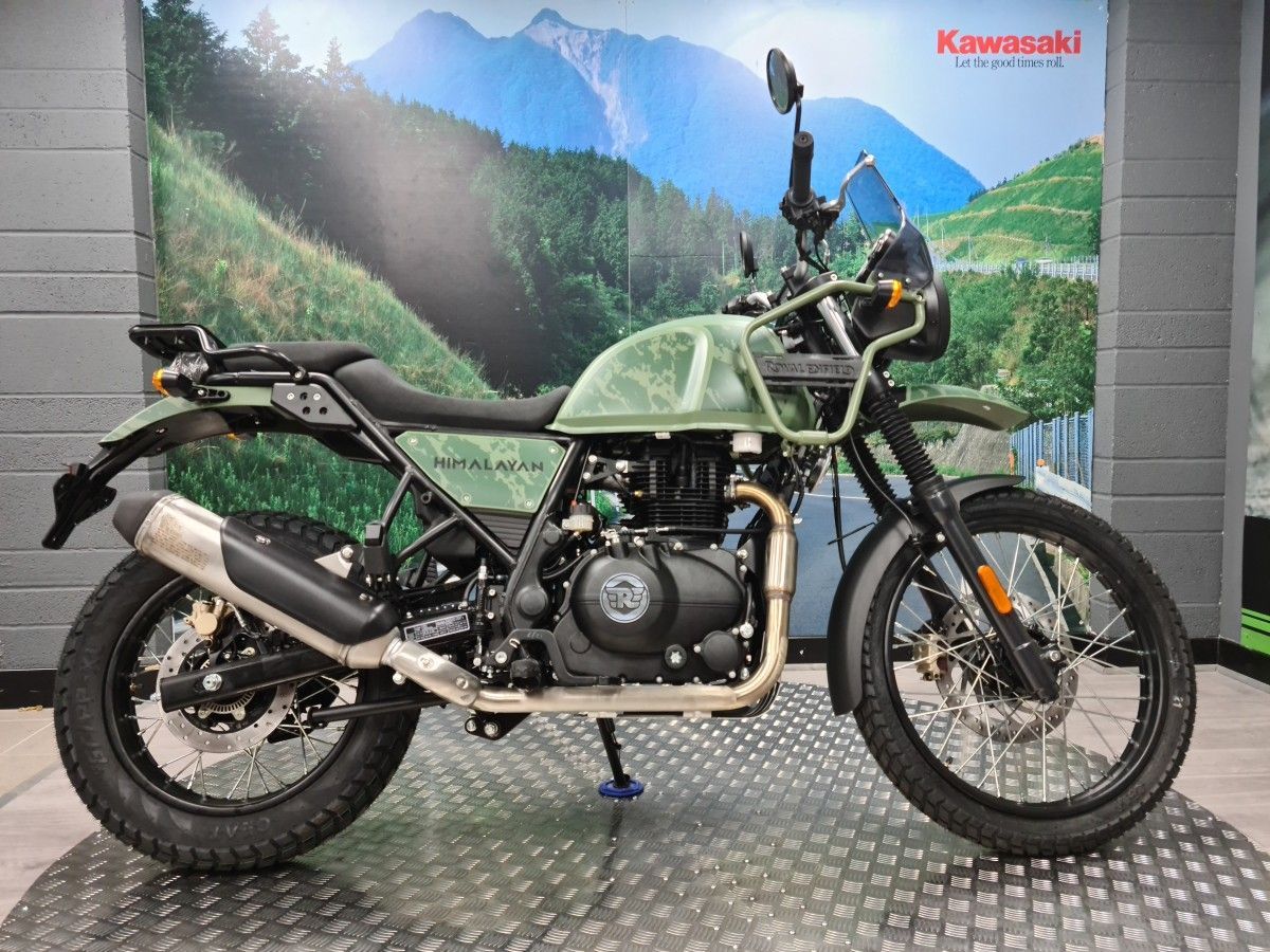 A motorcycle is sitting on top of a metal floor in a showroom.