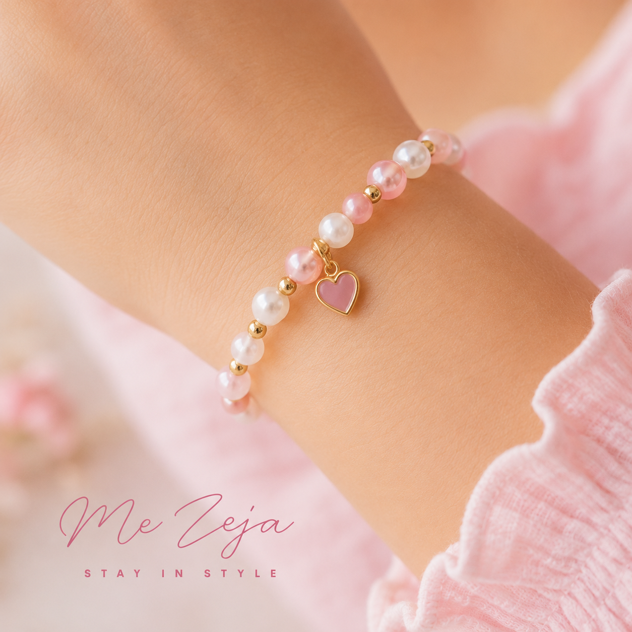 Pink beaded bracelet with a heart charm on a wrist, against a soft pink background
