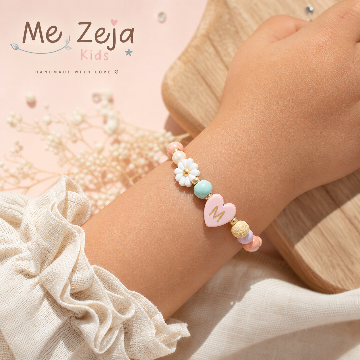 Pastel beaded bracelet with pink heart charm on a wrist beside soft fabric and wood surface