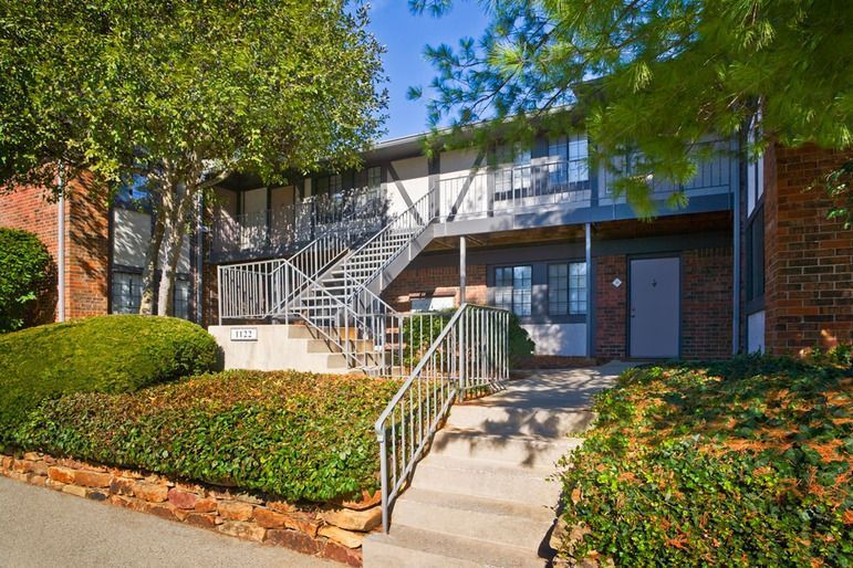 A brick apartment building with stairs leading up to it.
