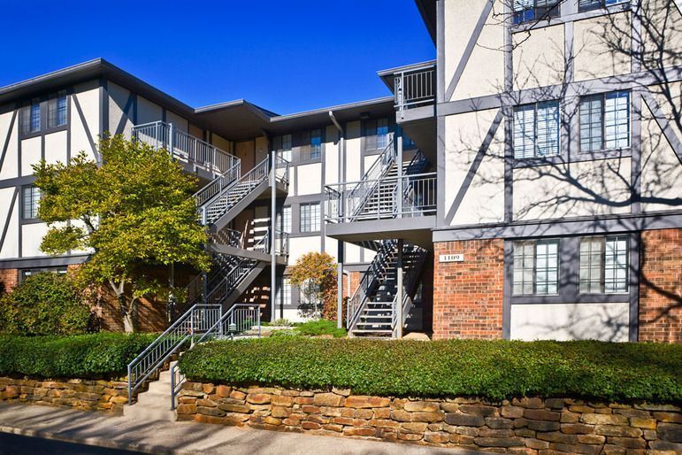A large apartment building with stairs leading up to the second floor.