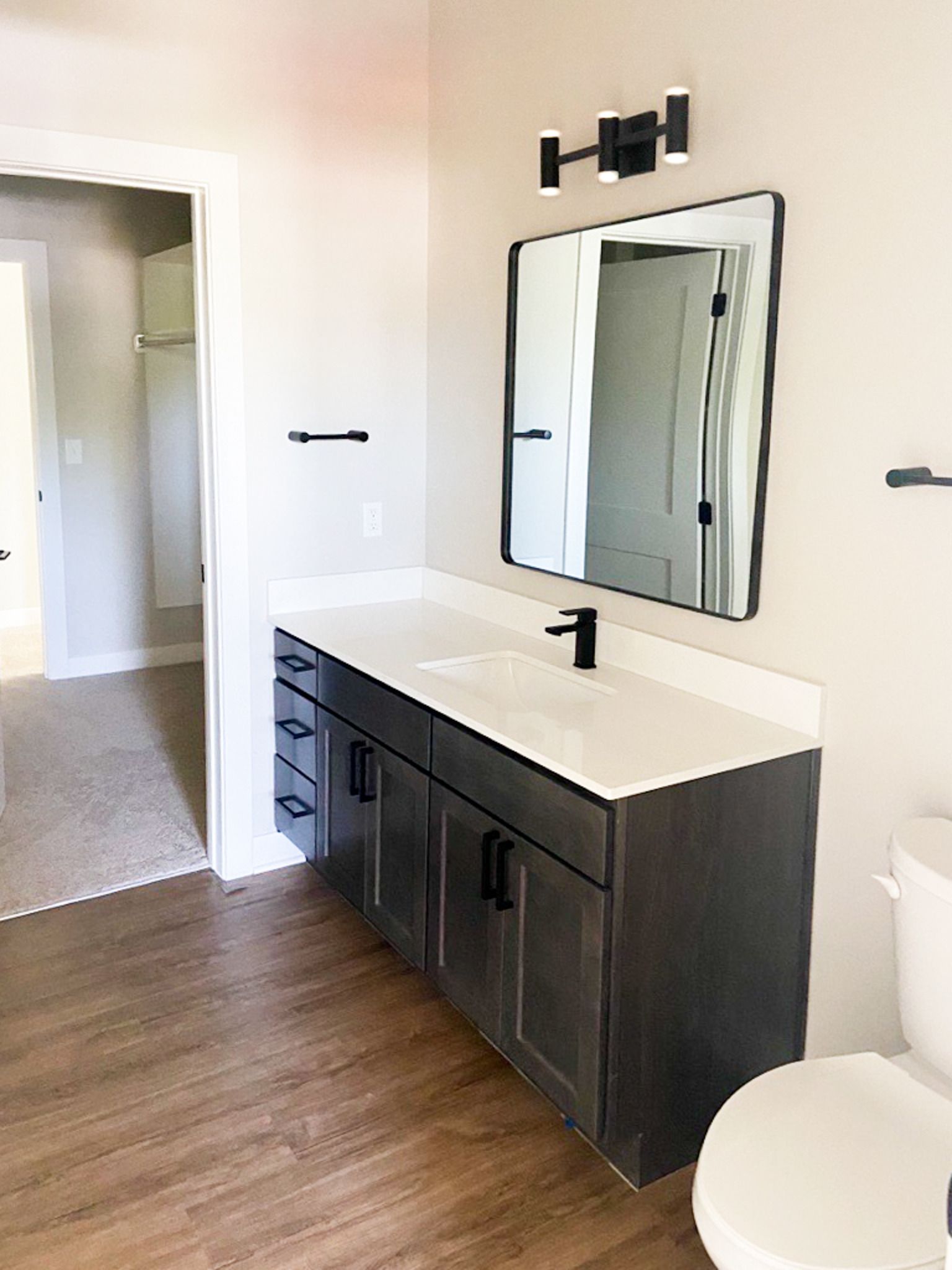 A bathroom with a sink , toilet and mirror.