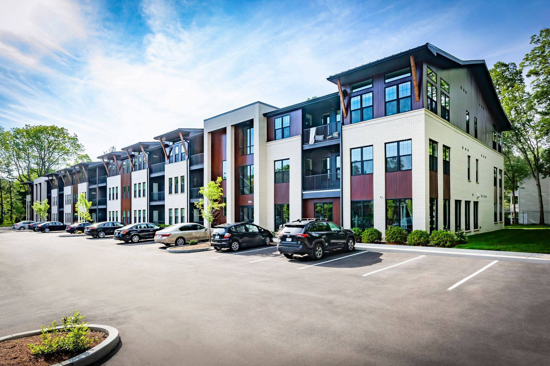 A large apartment building with cars parked in front of it.