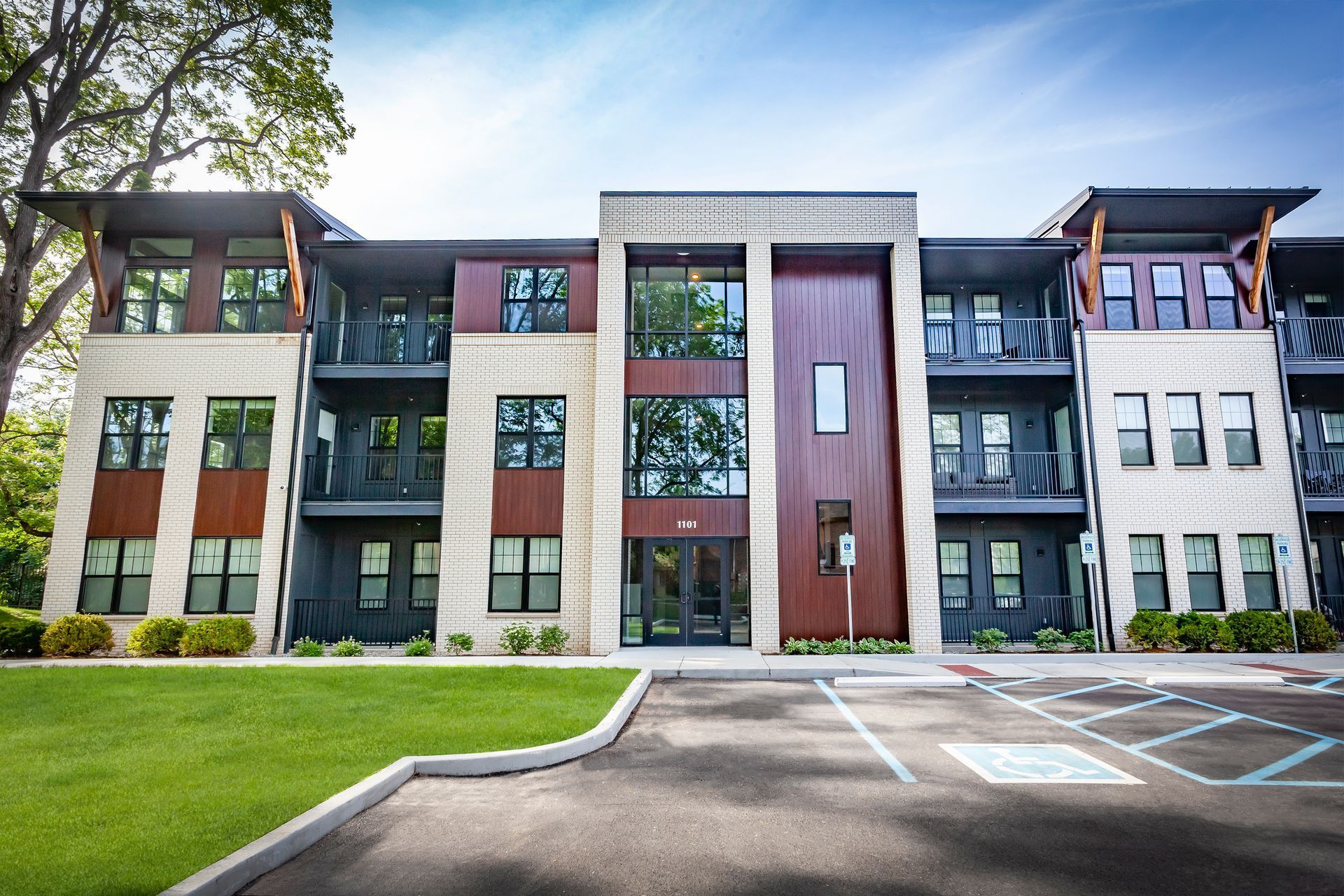 A large apartment building with a parking lot in front of it