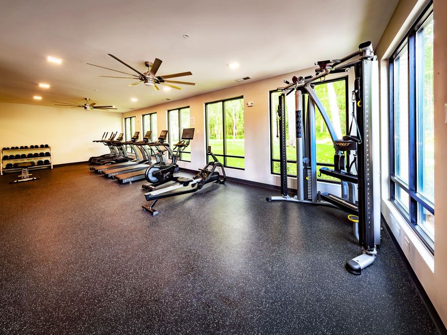 A large gym with a lot of equipment and a lot of windows.
