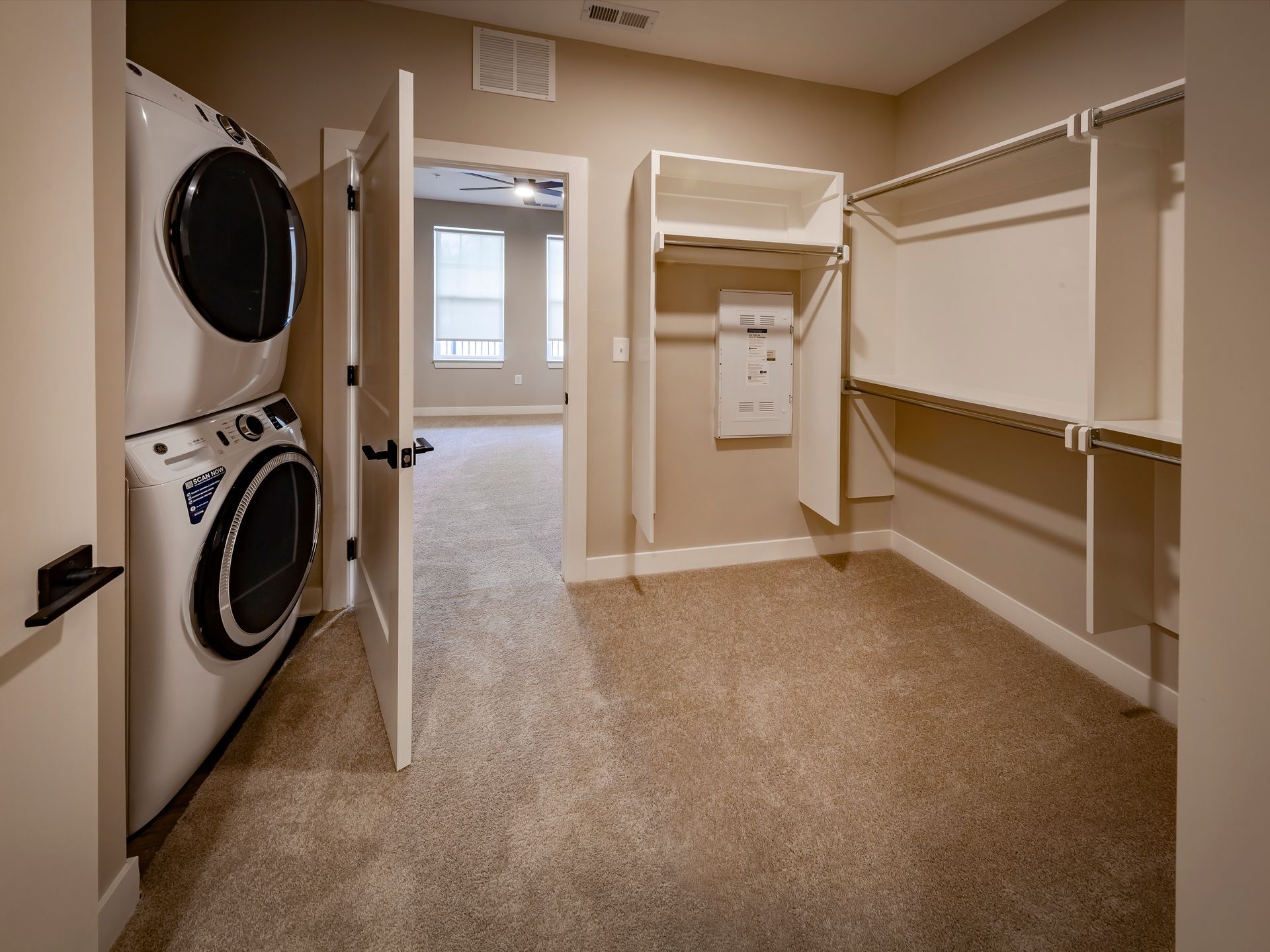 A walk in closet with a washer and dryer stacked on top of each other