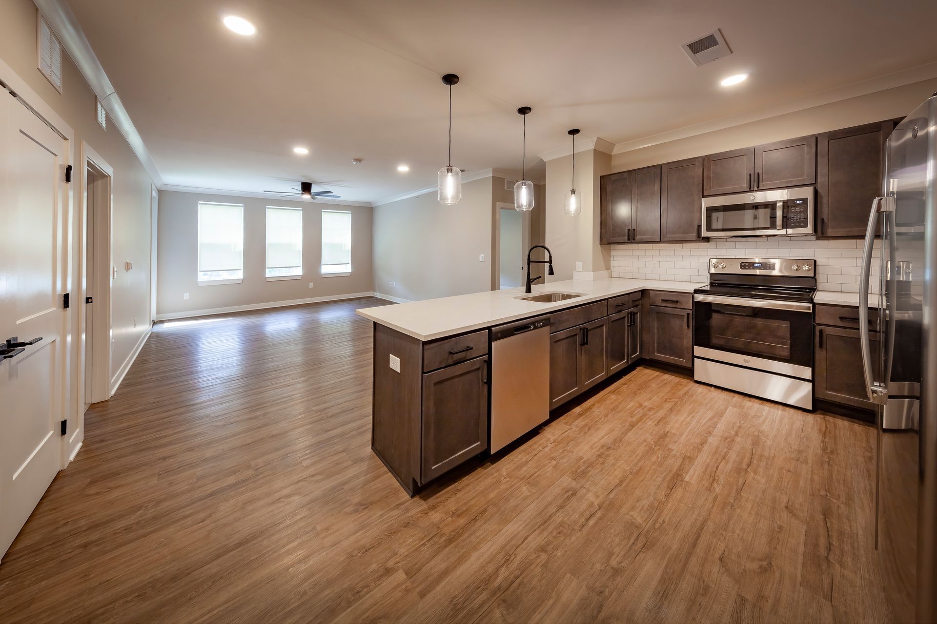 A kitchen with stainless steel appliances and wooden floors.