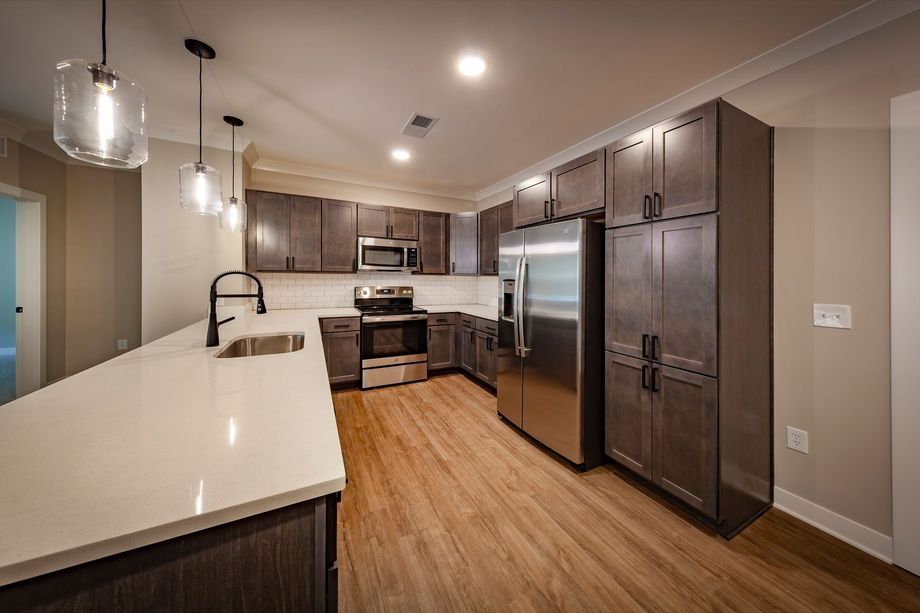 A kitchen with stainless steel appliances and wooden cabinets.