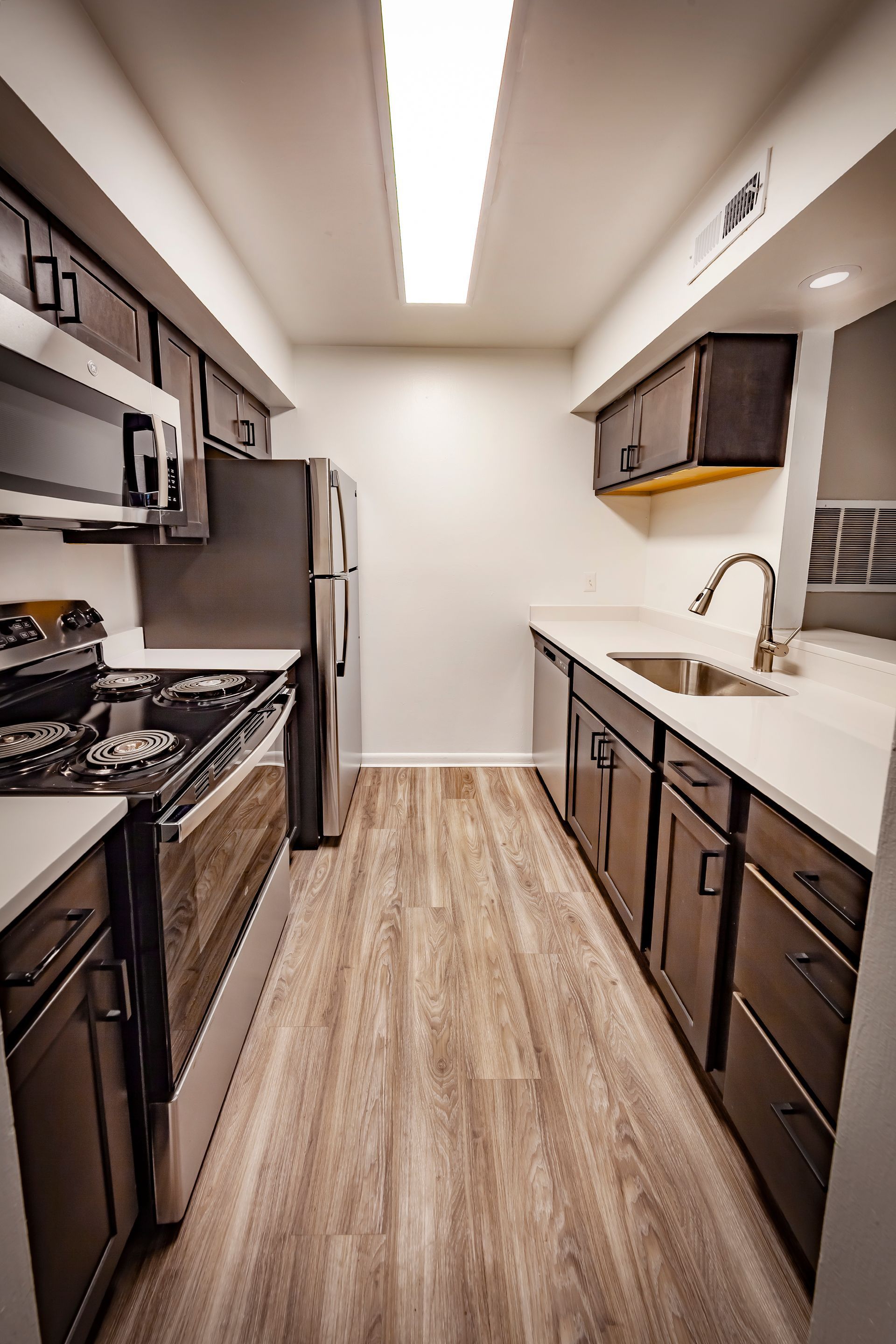 A kitchen with stainless steel appliances and wooden cabinets.