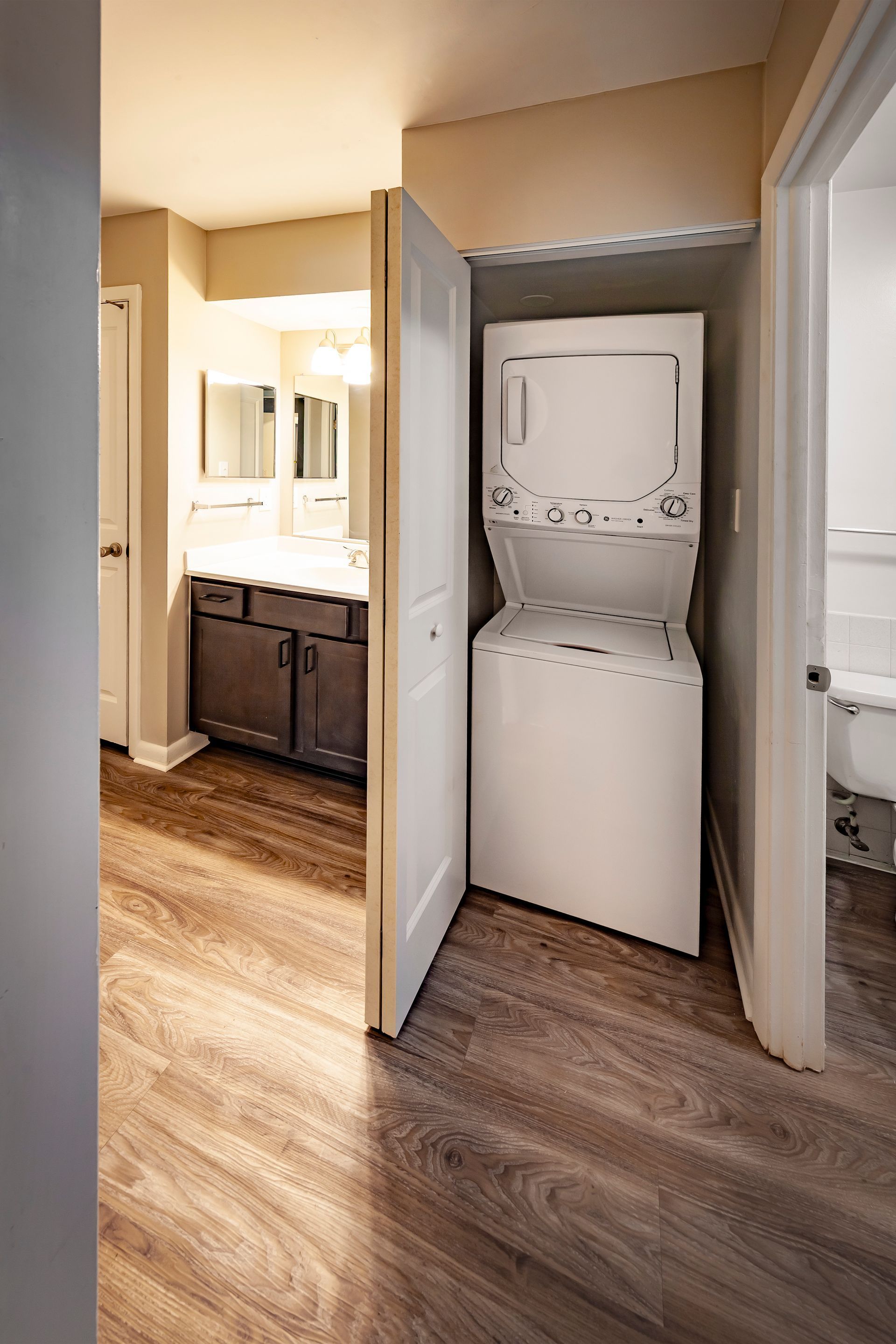 A washer and dryer are stacked in a closet in a bathroom.