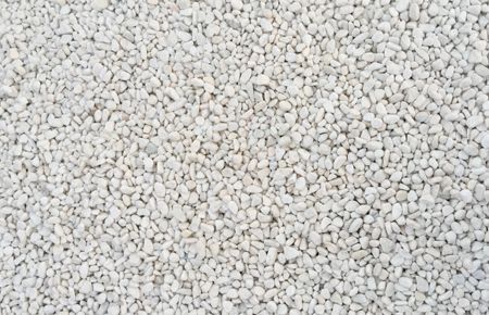 Close-up of a surface covered in small, light-colored, rounded gravel stones.