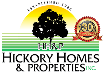 Logo for Hickory Homes & Properties Inc., featuring a black tree silhouette against a yellow and green background