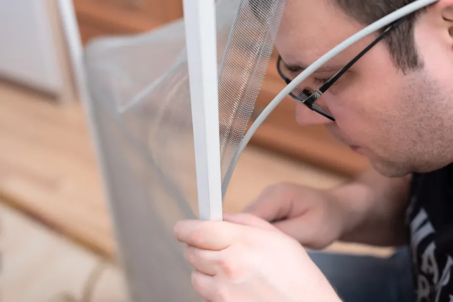 Man Fixing Window Screen Netting