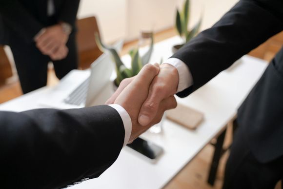 Businesspeople shaking hands in an office meeting room