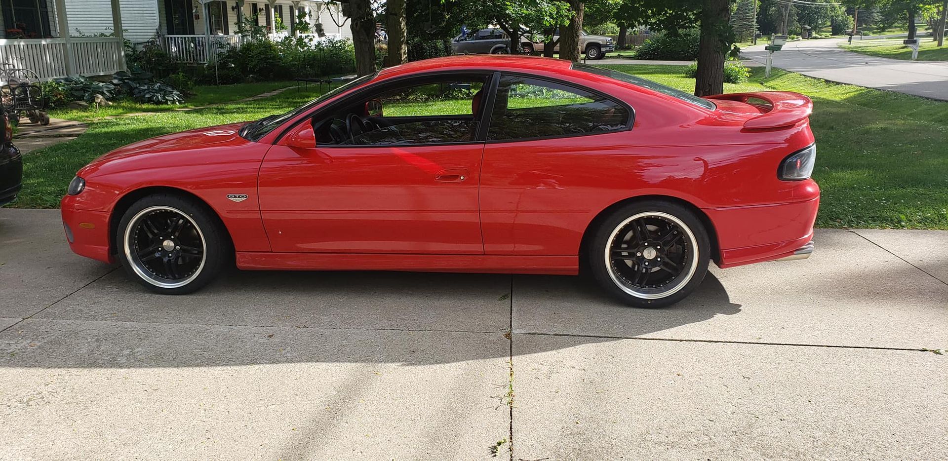 A red car is parked on the side of the road.