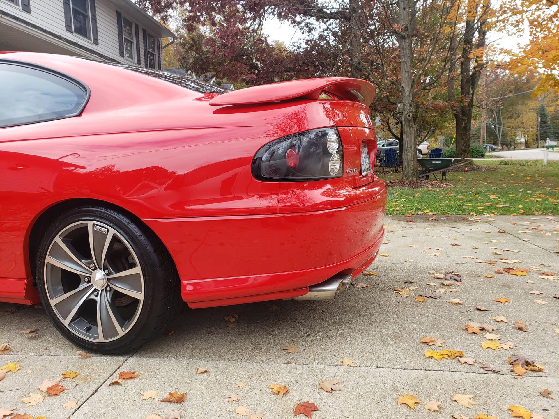 A red car is parked on the side of the road
