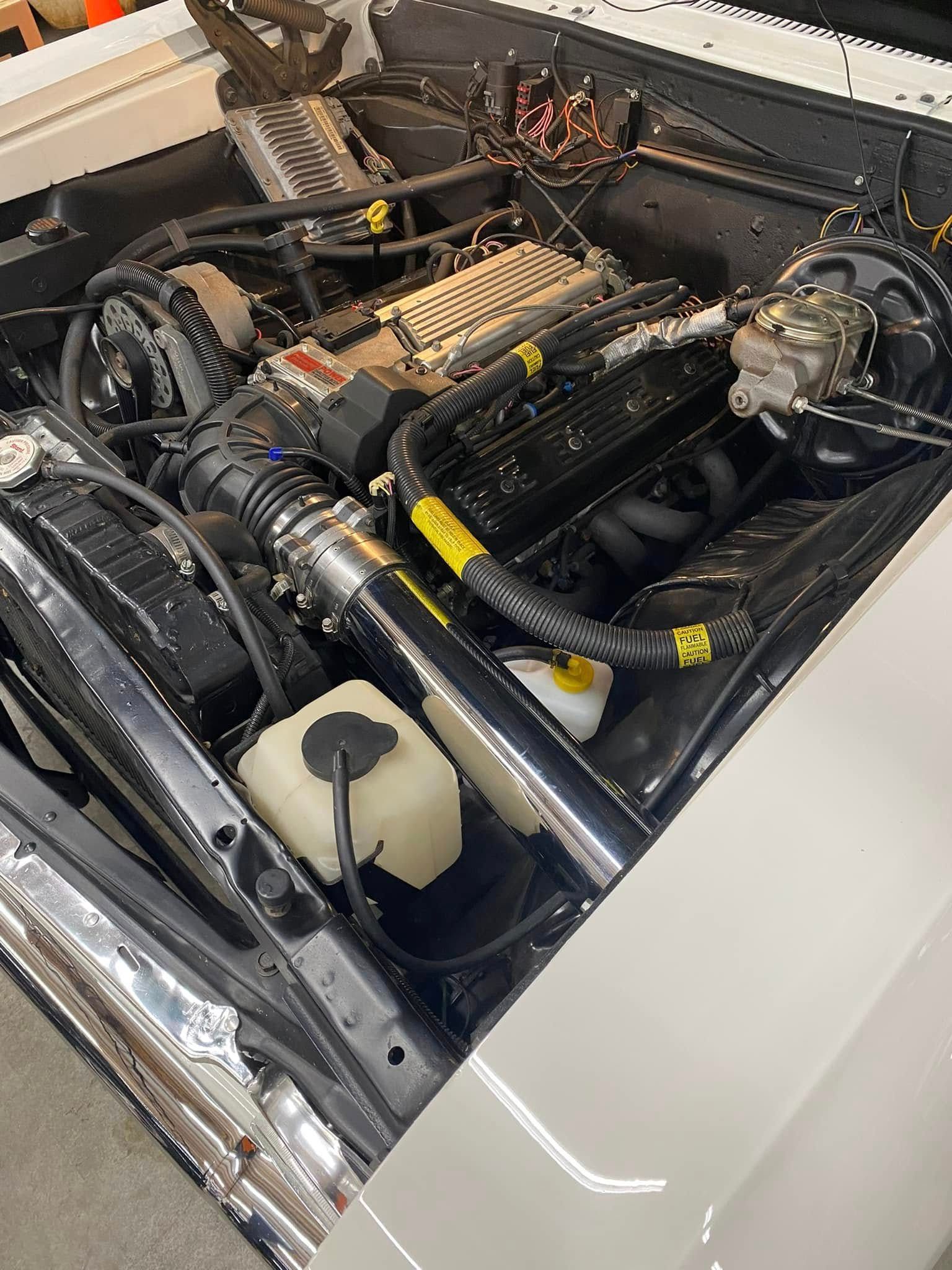 A close up of a car engine with the hood open.