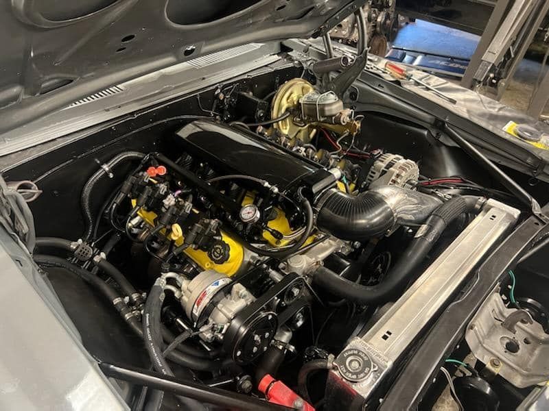 A close up of a car engine with the hood open.