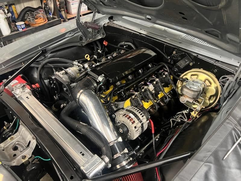 A close up of a car engine with the hood open.