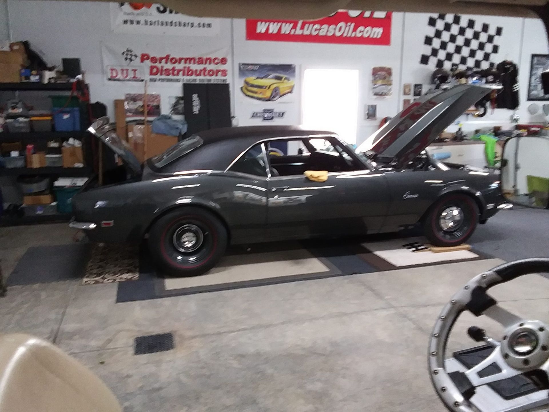 A car is parked in a garage with the hood up