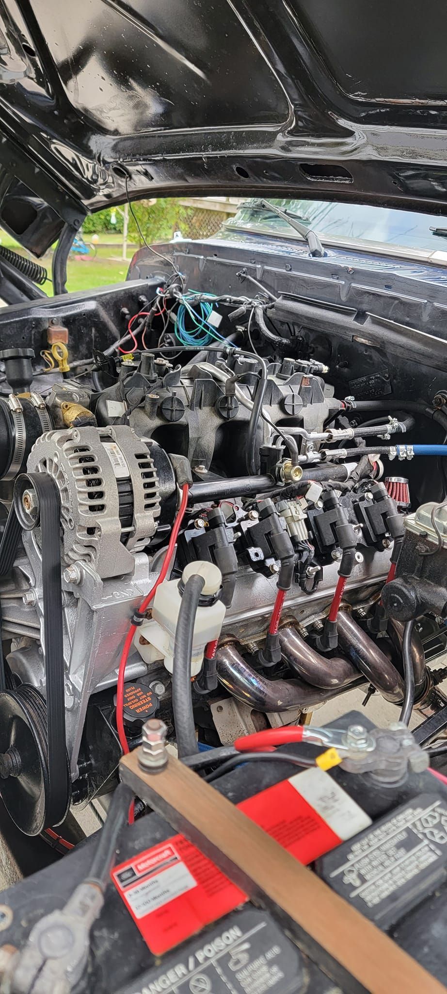A close up of a car engine with the hood open.