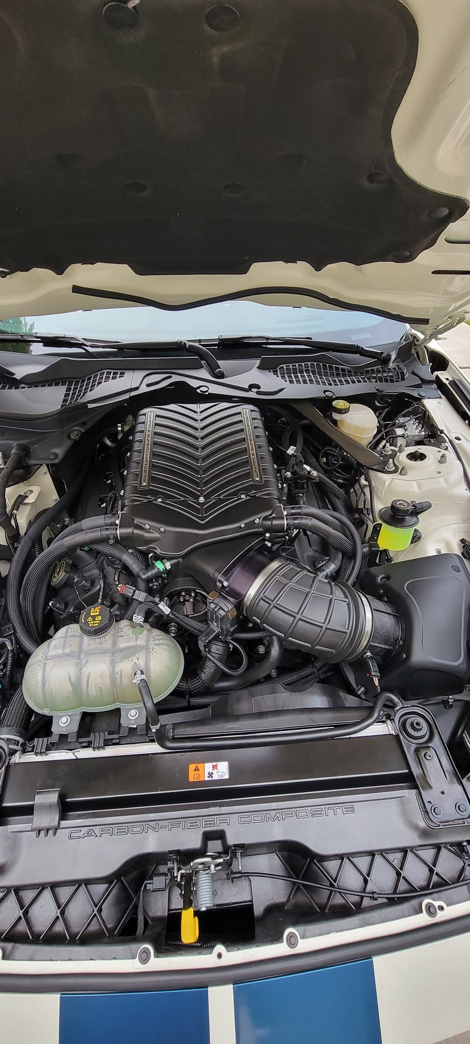 A close up of a car engine with the hood open.