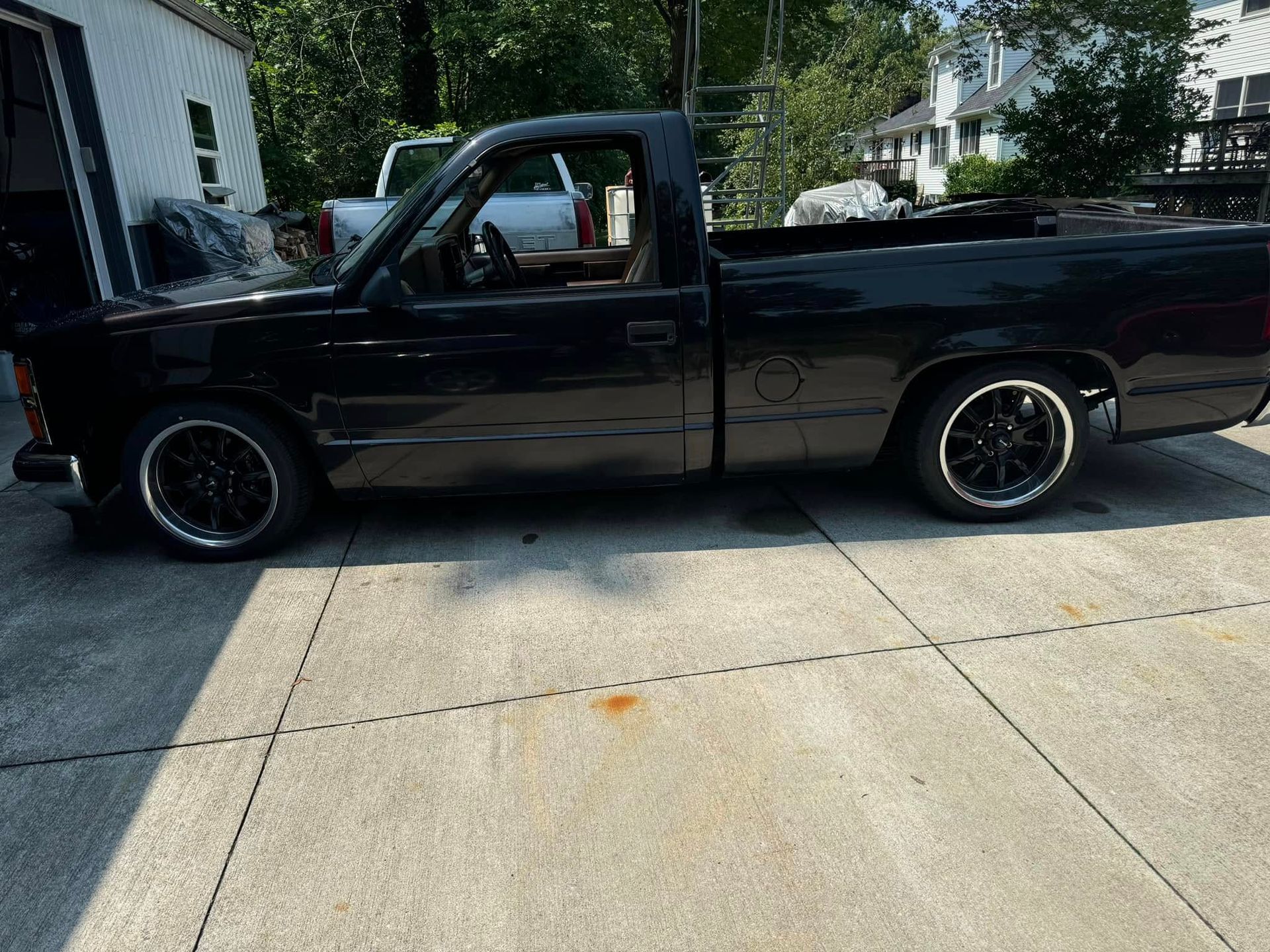 A black pickup truck is parked in a driveway.