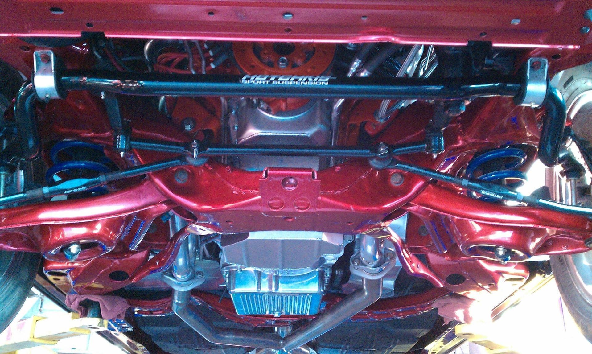The underside of a red car with the word racing on it