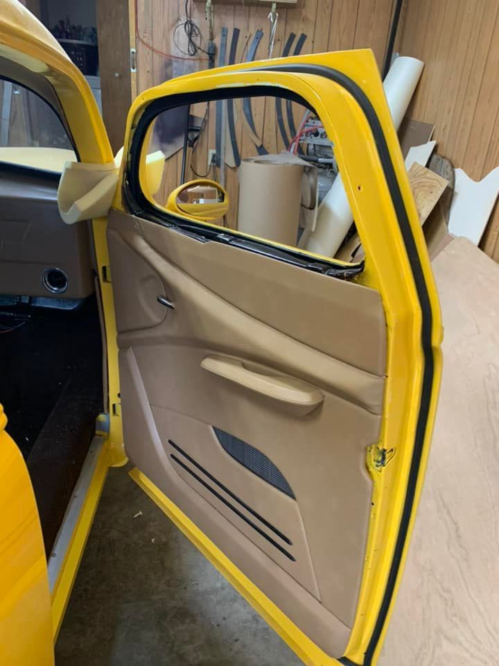 A yellow car with the door open in a garage