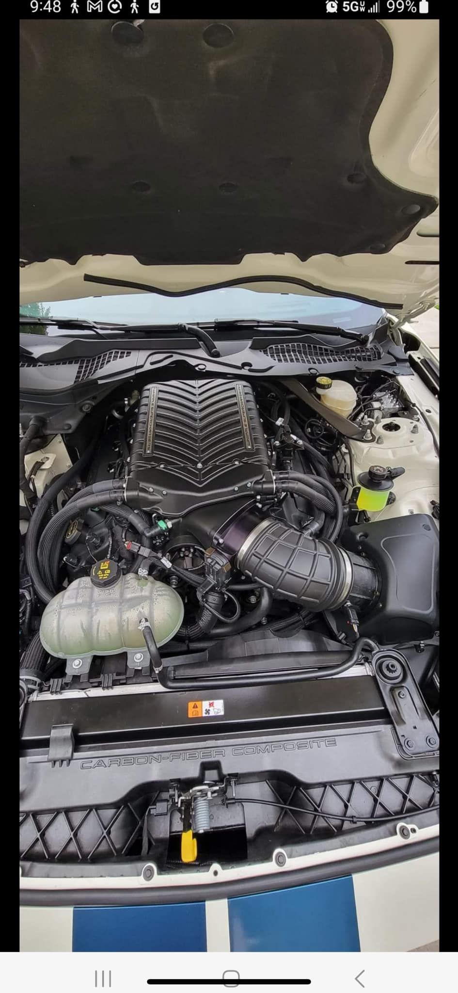A close up of a car engine with the hood up.