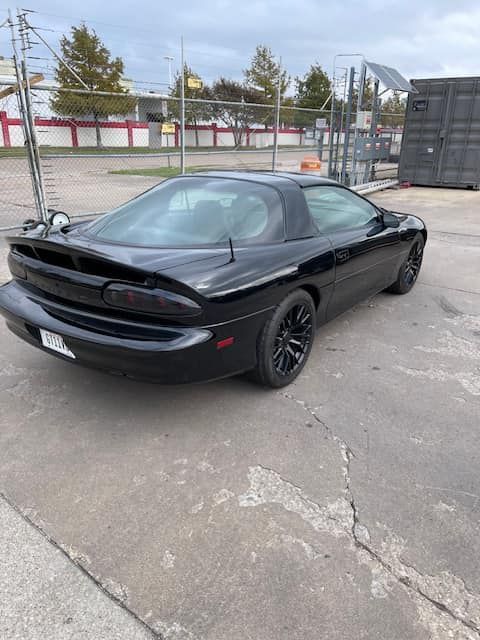 A black car is parked in a parking lot.
