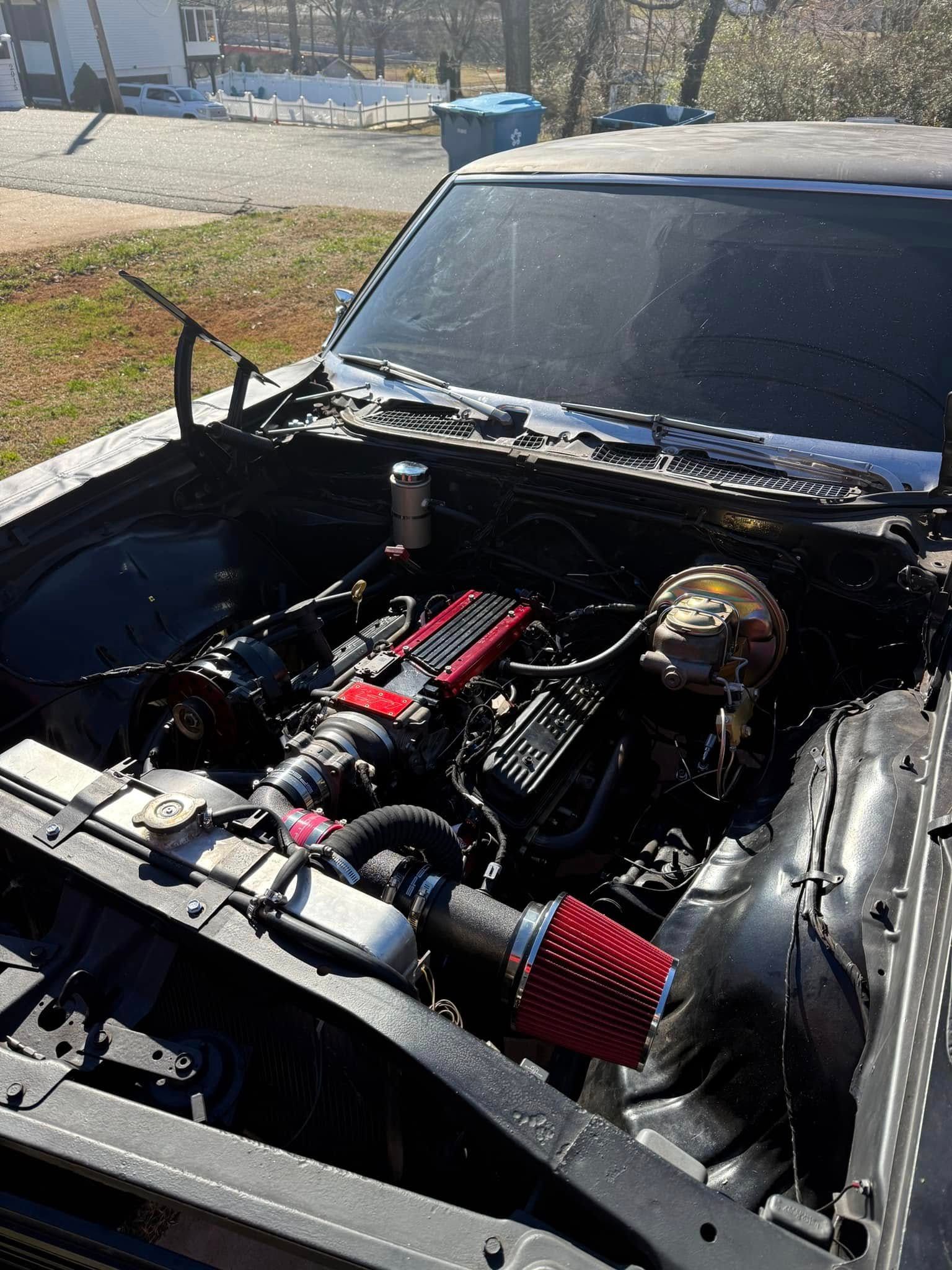 The engine of a black car with the hood open