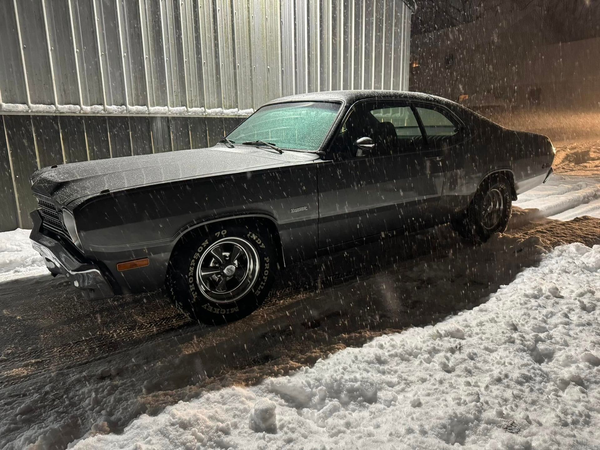 A car is parked in the snow in front of a building.