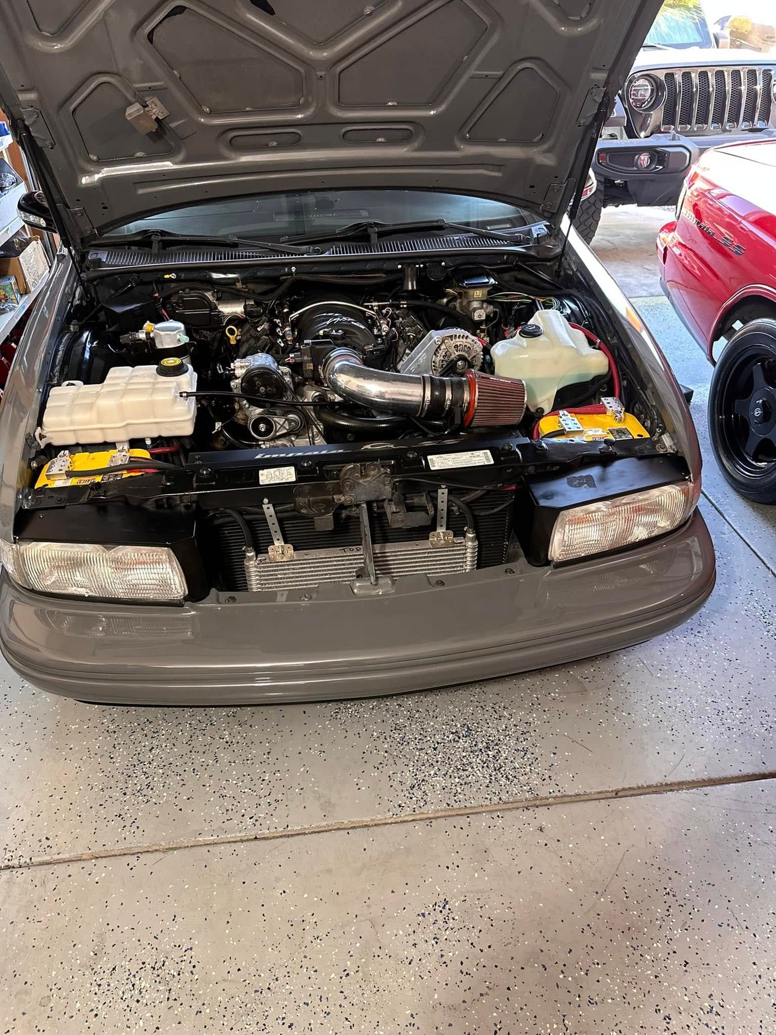 The hood of a car is open and the engine is visible.