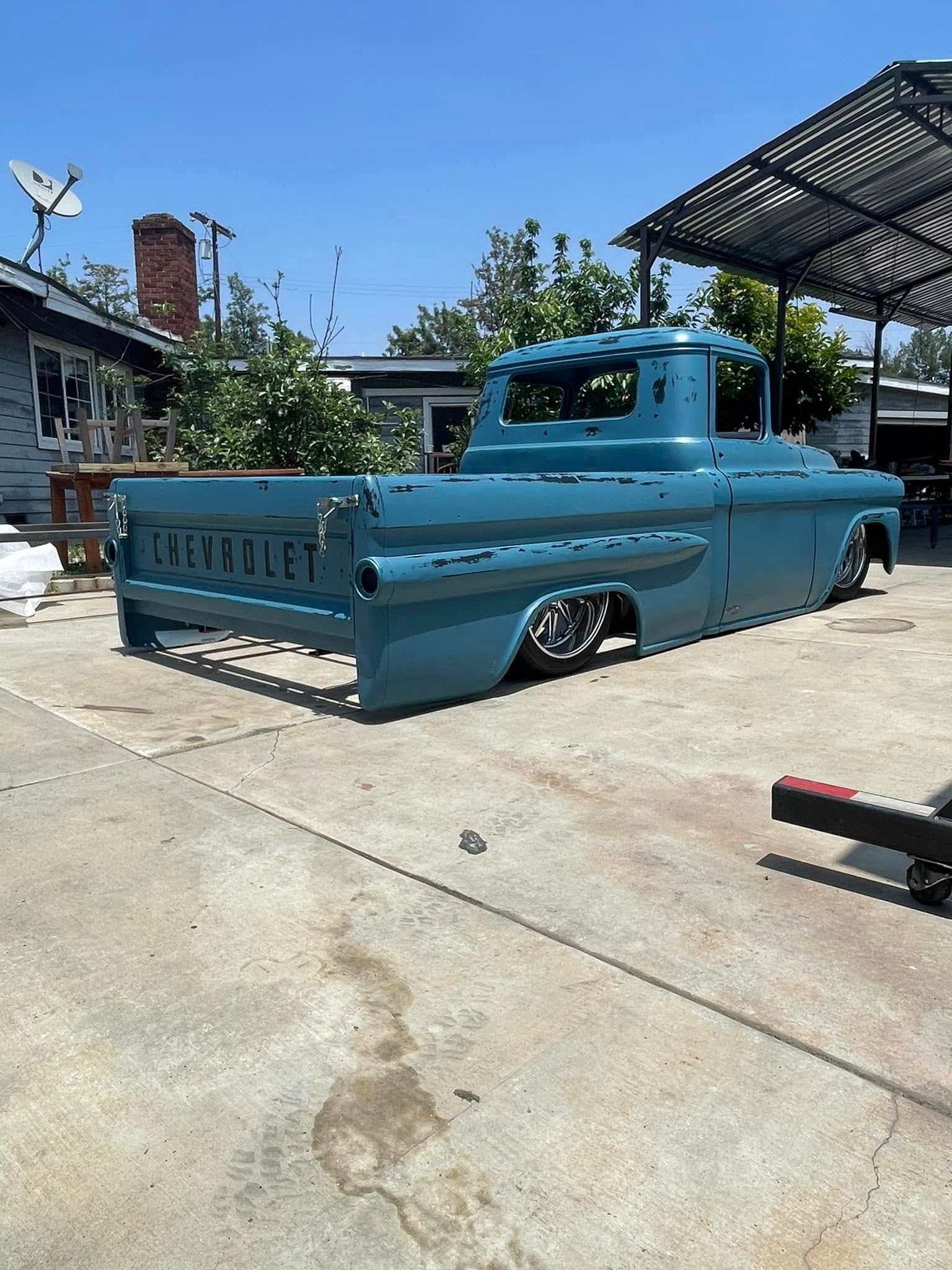 A blue chevrolet truck is parked in a driveway