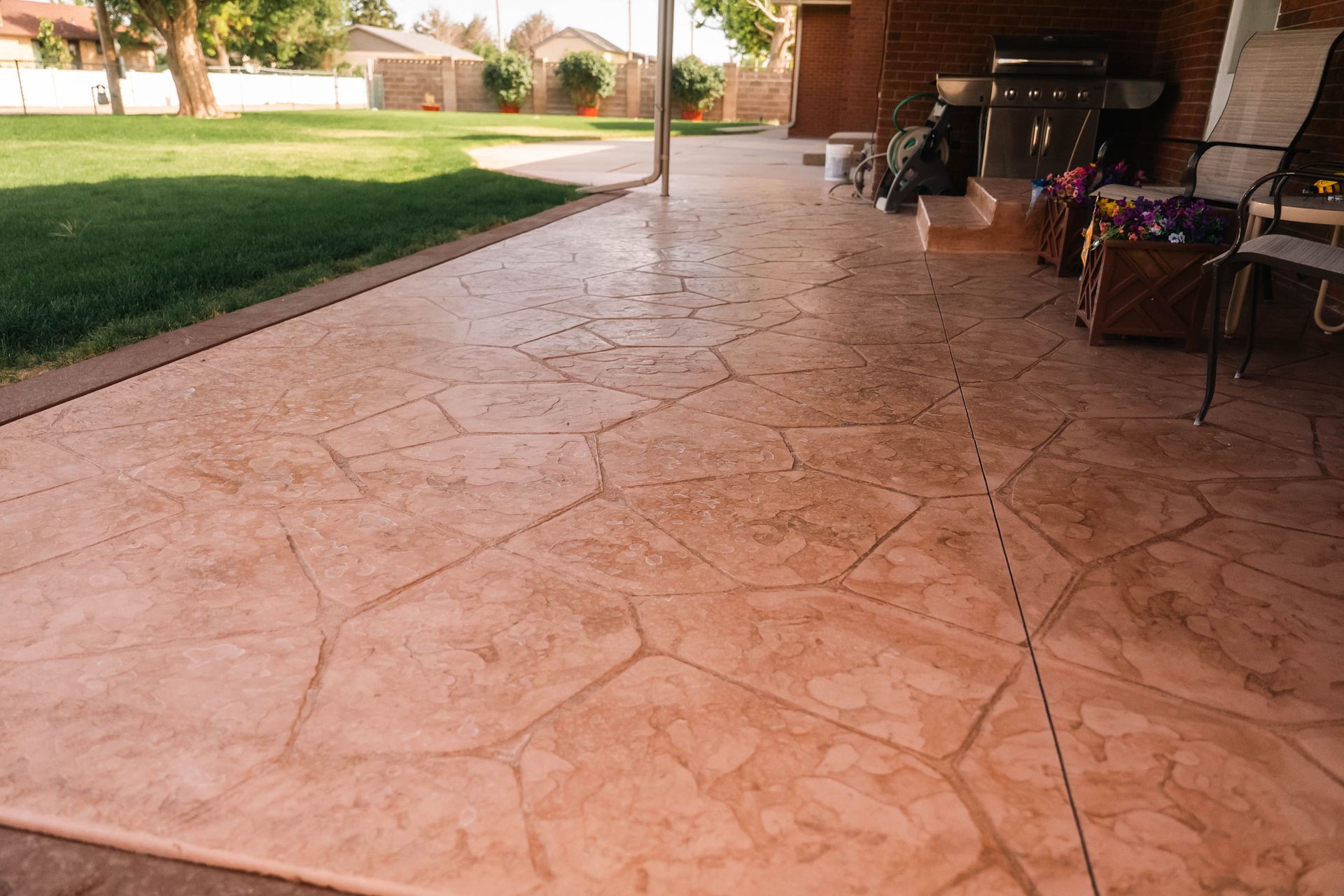 Stamped concrete patio with a natural stone pattern, tan color.