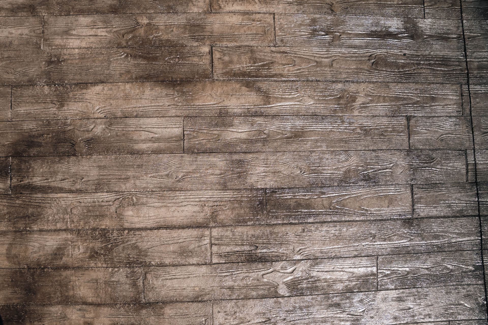 Weathered, brown wooden planks with light and dark patches, possibly a floor or deck.