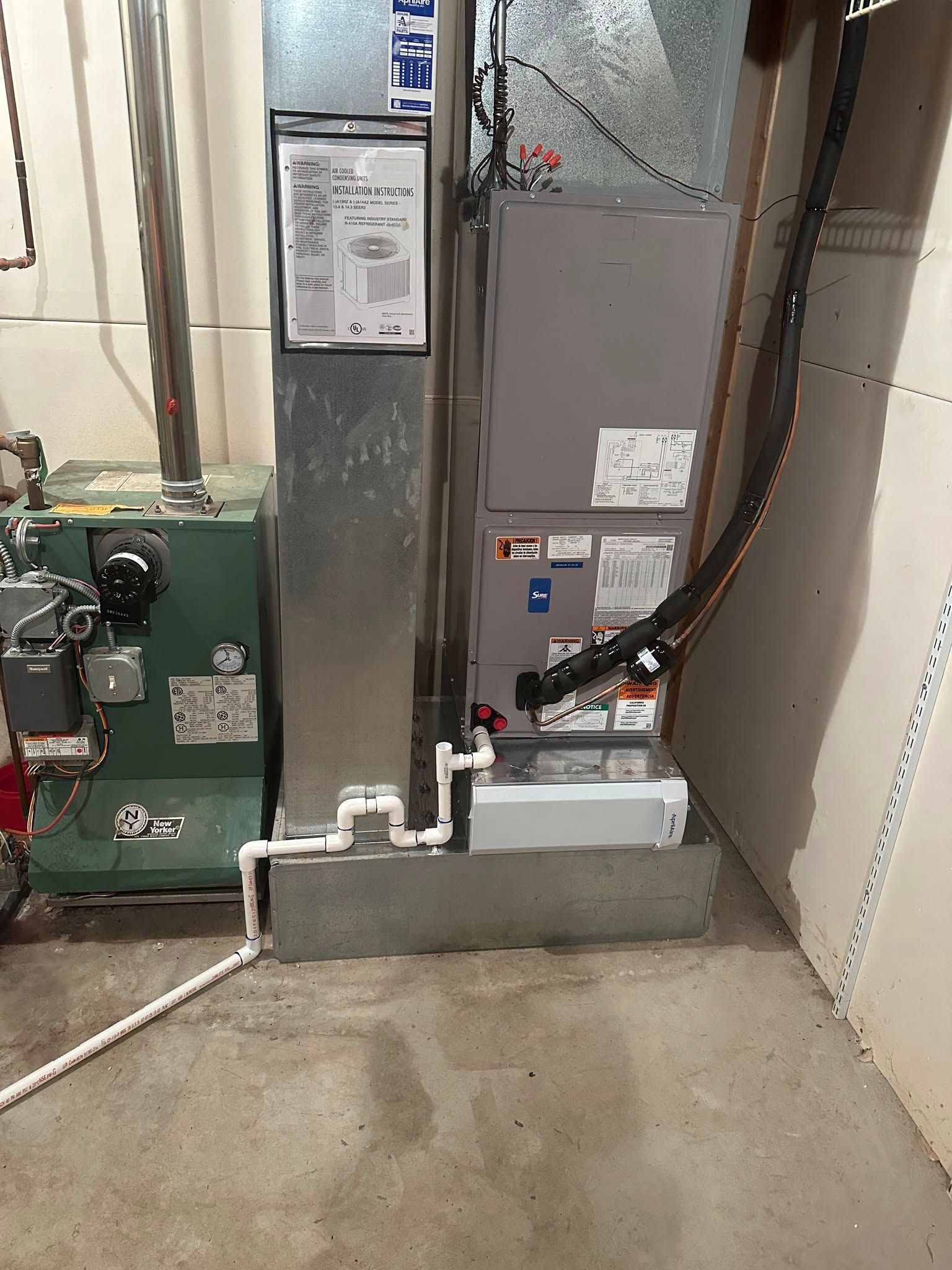 Mechanical HVAC equipment in a basement utility room with pipes and concrete floor